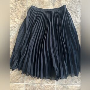Black pleated skirt below the knee
